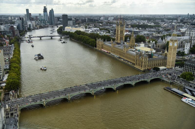 People queue on a bridge over the river Thames to pay their respects to Queen Elizabeth in London. Reuters