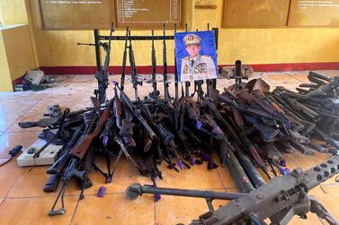 Seized weapons of the army are seen together with the photo of Senior Gen.  Min Aung Hlaing, the head of the ruling military council, in a building of a military outpost in Kunlong township in Shan state, Myanmar, Sunday, Nov.  12, 2023.  (The Kokang online media via AP)