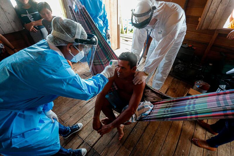 Government health workers check the temperature of a man at a Murutipucu River riverside community in Igarape-Miri, Baixo Tocantins, Para state, Brazil. AFP