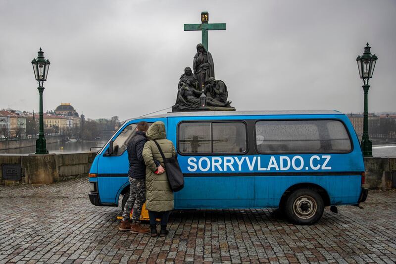 A couple looks inside a van parked on Charles Bridge in Prague, Czech Republic, in a protest against the government's new coronavirus measures. EPA