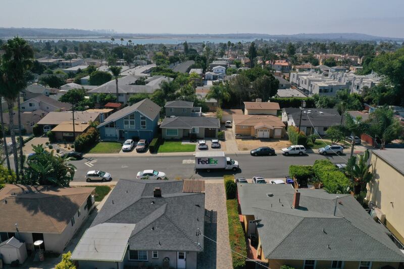 A FedEx Corp. truck drives past homes in this aerial photograph taken over the Pacific Beach neighborhood of San Diego, California, U.S., on Wednesday, Sept. 2, 2020. U.S. sales of previously owned homes surged by the most on record in July as lower mortgage rates continued to power a residential real estate market that's proving a key source of strength for the economic recovery. Photographer: Bing Guan/Bloomberg