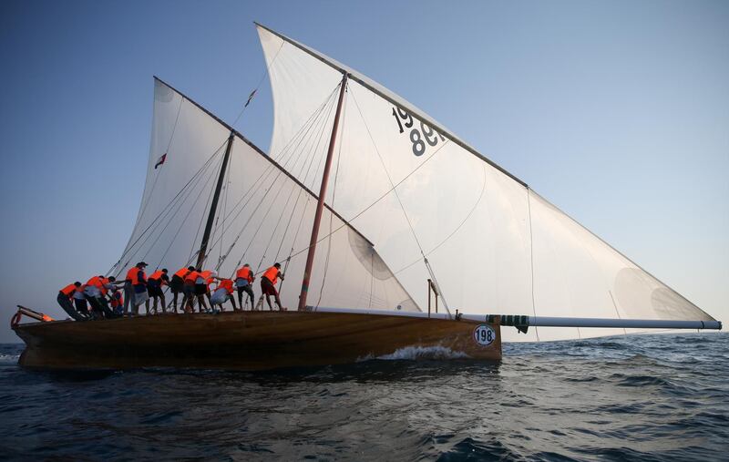 A dhow crew raise the sails on their vessel. EPA