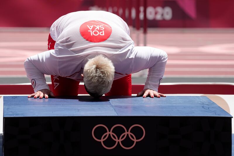 Gold medalist Anita Wlodarczyk, of Poland, kisses the podium during the medal ceremony for the women's hammer throw.