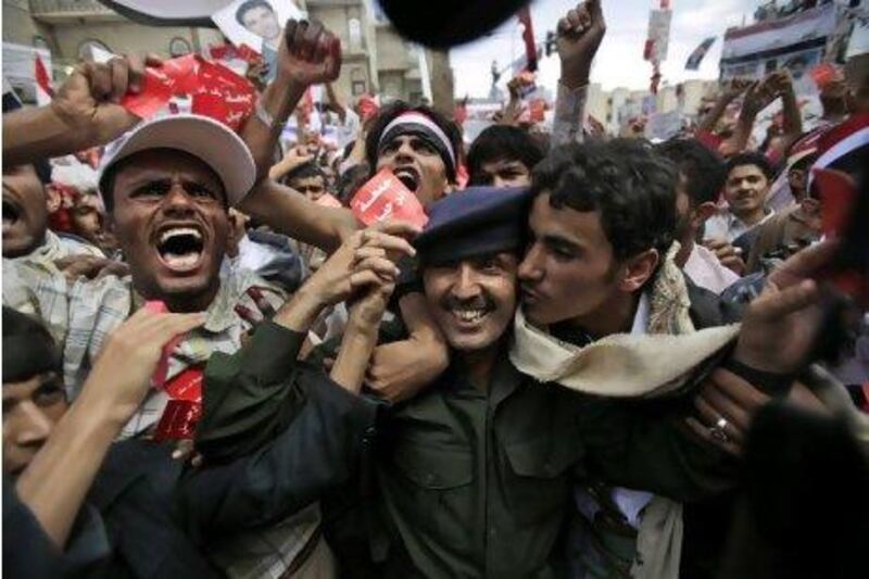 A Yemeni army officer, centre, is kissed by an anti-government protestor during a demonstration on March 25 in Sana'a.