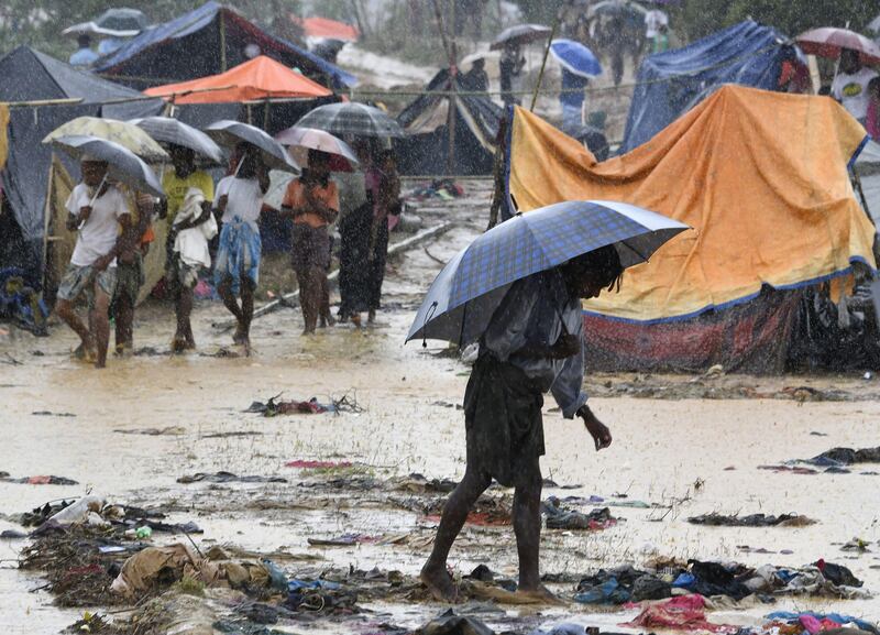 A Rohingya refugee holds an umbrella during rain in Bangladesh's Balukhali refugee camp. Dominique Faget / AFP Photo