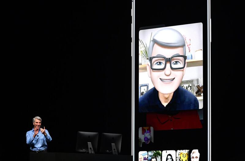 Apple CEO Tim Cook (L) speaks using his Memoji during a group FaceTime call on stage during Apple's Worldwide Developer Conference (WWDC) at the San Jose Convention Centerin San Jose, California on Monday, June 4, 2018.  / AFP / Josh Edelson
