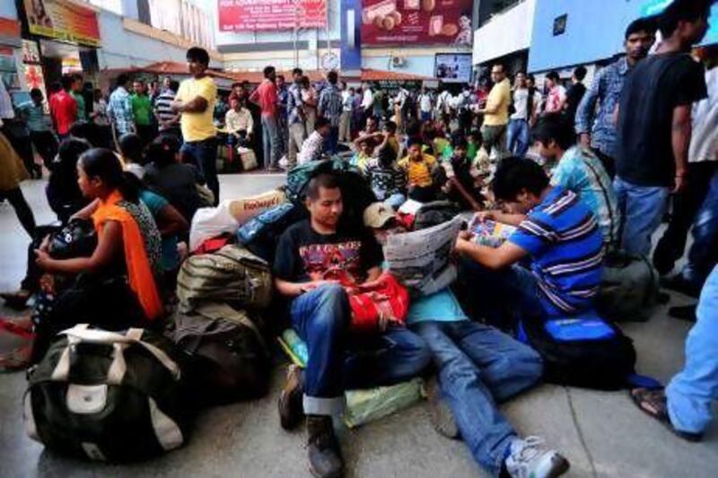 Hundreds of fearful migrant students and workers from north-eastern part of Assam gather at the Bangalore railway station after a rumour of possible violence spread.