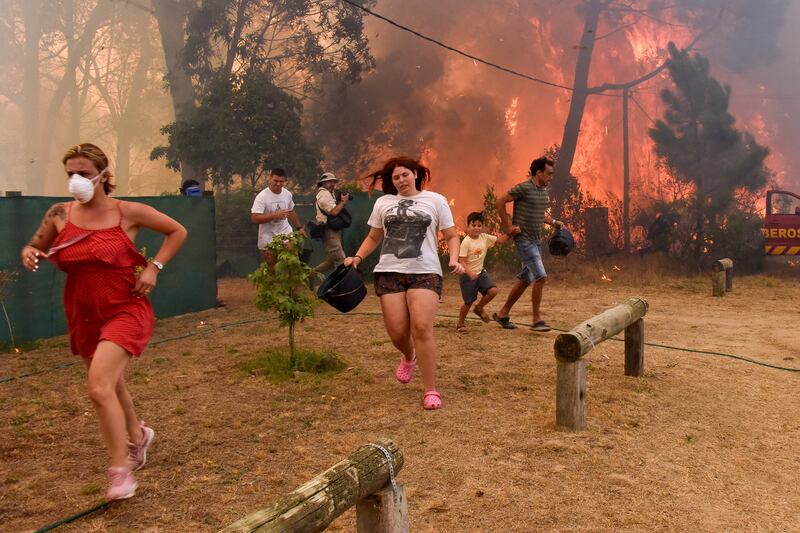 People flee from flames in La Floresta, Uruguay, where a wildfire was fanned by intense winds and dry conditions. EPA