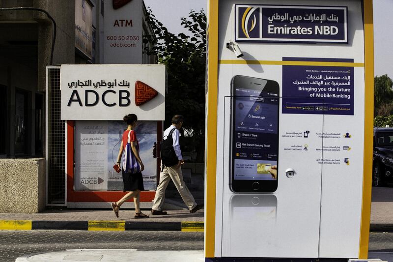 Pedestrians pass automated teller machines (ATM) operated by Emirates NBD PJSC and Abu Dhabi Commercial Bank PJSC (ADCB) banks in Dubai, United Arab Emirates, on Tuesday, Sept. 4, 2018. Abu Dhabi is engineering a second bank merger in its latest attempt to stay competitive in the era of lower oil prices. Photographer: Christopher Pike/Bloomberg