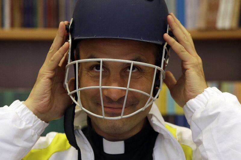 Monsignor Sanchez de Toca y Alameda, undersecretary of the Pontifical Council for Culture, puts on a cricket helmet. Gregorio Borgia / AP Photo