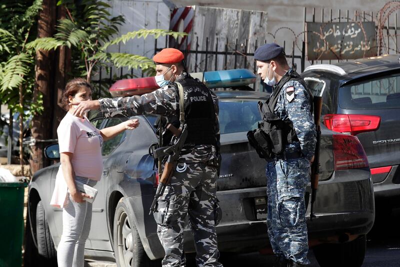 A relative of a prisoner speaks with Lebanese policemen outside the detention center of Baabda courthouse compound were nearly 70 inmates broke out of a prison early Saturday after smashing their cell doors and attacking prison guards, in the Beirut southeastern suburb of Baabda, Lebanon. AP