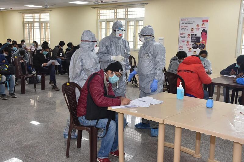 epa08251853 A handout photo made available by the Indo-Tibetan Border Police (ITBP) shows officials wearing protective suits stand in a room with evacuees, who have been taken out of the Chinese city of Wuhan, inside the Chhawla Quarantine Facility in New Delhi, India, 27 February 2020. A group of 76 Indians and 36 foreign nationals, including eight families with children, have been evacuated by the Indian government from Wuhan, the epicenter of the novel coronavirus outbreak, and kept in the Chhawala quarantine facility. According to authorities, so far none of the evacuees has been tested positive to the Covid-19 disease.  EPA/INDO-TIBETAN BORDER POLICE HANDOUT -- BEST QUALITY AVAILABLE -- HANDOUT EDITORIAL USE ONLY/NO SALES/NO ARCHIVES