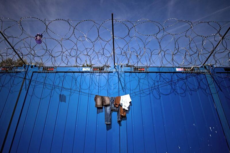 Clothes hang on barbed wires at a makeshift refugee and migrants camp near the Serbian town of Horgos, which is close to the border with Hungary, on September 29, 2016. The flow of migrants through the Balkans toward western Europe has continued despite the closure of the 'Balkan route' in March. More than 5,000 migrants have been stranded in Serbia looking for ways to cross to EU member states of Hungary and Croatia. Andrej Isakovic / Agence France-Presse