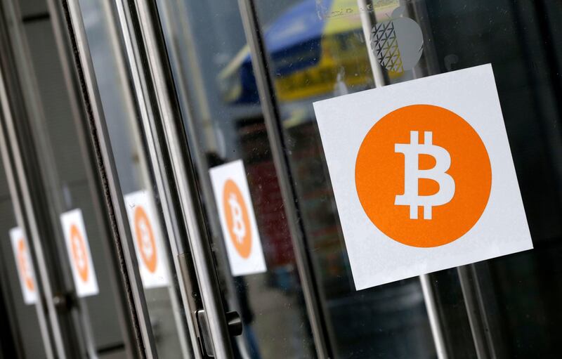FILE - In this April 7, 2014, file photo, Bitcoin logos are displayed at the Inside Bitcoins conference and trade show in New York. The threat of a split in bitcoin has been avoided for now. A move by users to force a change in the computer code by July 31, 2017, has worked, with the majority of so-called â€œminers,â€ who are rewarded for verifying transactions, signaling support. The change is designed to improve capacity on the increasingly clogged network. (AP Photo/Mark Lennihan, File)