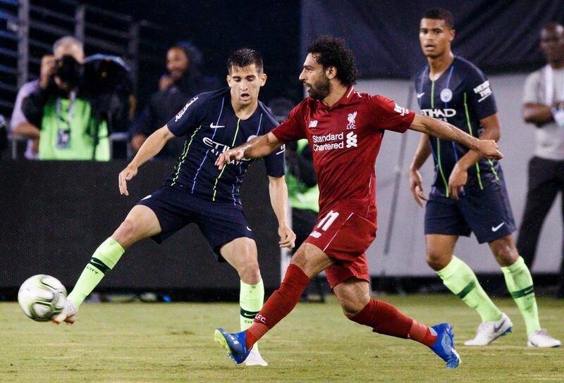 epa06910747 Mohammed Salah (C) of Liverpool dribbles past Phil Foden (L) and Cameron Humphreys (R) of Manchester City during the second half of the International Champions Cup soccer match between Manchester City and Liverpool at MetLife Stadium in East Rutherford, New Jersey, USA, 25 July 2018.  EPA/JUSTIN LANE