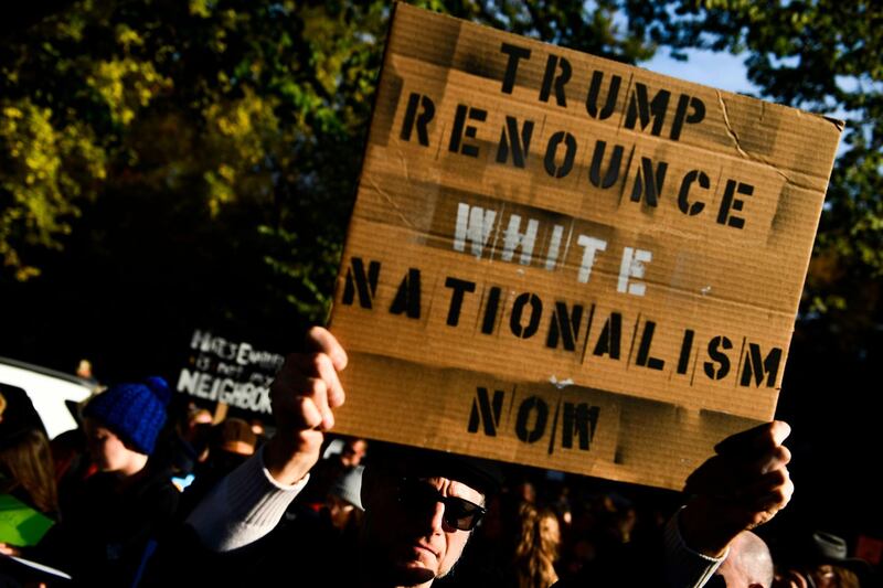 TOPSHOT - People protesting against US President Donald Trump wait near the Tree of Life Congregation on October 30, 2018 in Pittsburgh, Pennsylvania.  The first two victims of the deadliest anti-Semitic attack in recent US history were laid to rest in Pittsburgh on Tuesday as the grieving city awaits a controversial visit by President Donald Trump and his wife Melania.Trump's visit to the city has been contentious, coming amid a mounting row over whether his fierce rhetoric at campaign rallies and on Twitter has helped stoke extremism ahead of November 6 midterm elections. A protest in Pittsburgh against the president has been called for Tuesday afternoon. / AFP / Brendan Smialowski
