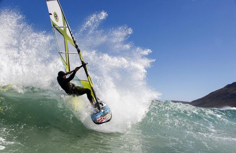 A windsurfer rides a wave in the Atlantic Ocean off the south peninsula of Cape Town, South Africa on Friday. Unseasonal strong winds for autumn in the cape have provided good conditions for windsurfing. Nic Bothma / EPA / April 4, 2014 