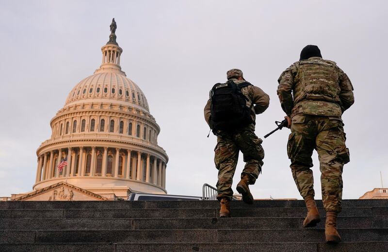 FILE PHOTO: National Guard members walk at the Capitol, in Washington, U.S., January 15, 2021. REUTERS/Joshua Roberts/File Photo