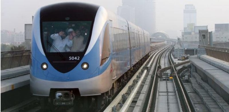 Passengers wave from a passing train seen from on board the first train of the day on the Dubai Metro network which pulled out of the Nakheel  Harbour & Tower station at 6am in Dubai on September 10, 2009.