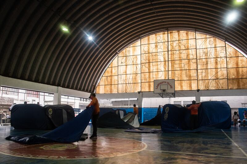 Officials set up tents in a basketball court to serve as an evacuation centre in Marikina City, suburban Manila. AFP