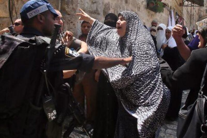 An Israeli border policeman restrains a Palestinian woman from entering the Haram Al Sharif, home to Islam's third holiest site, following clashes in the area.