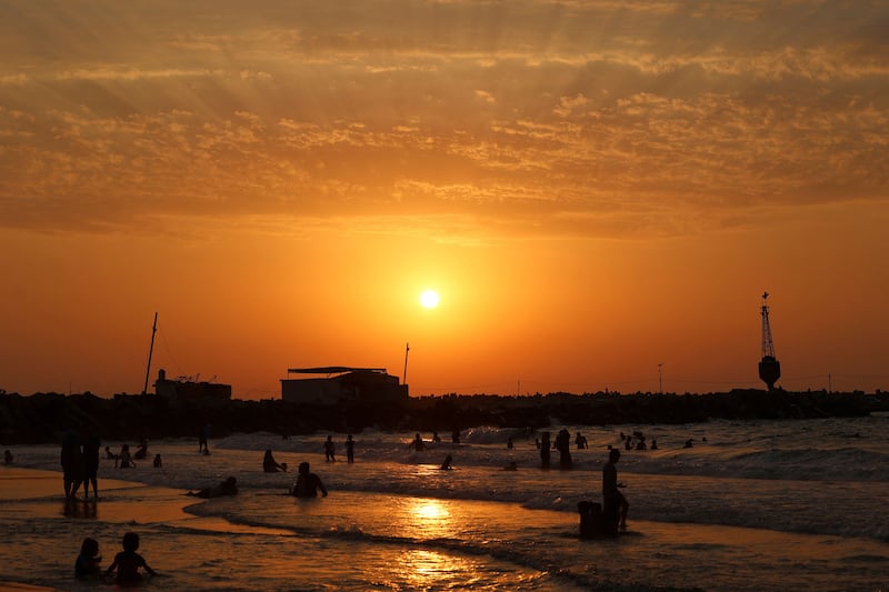 Palestinians gather at the beach at sunset in Gaza City. AFP