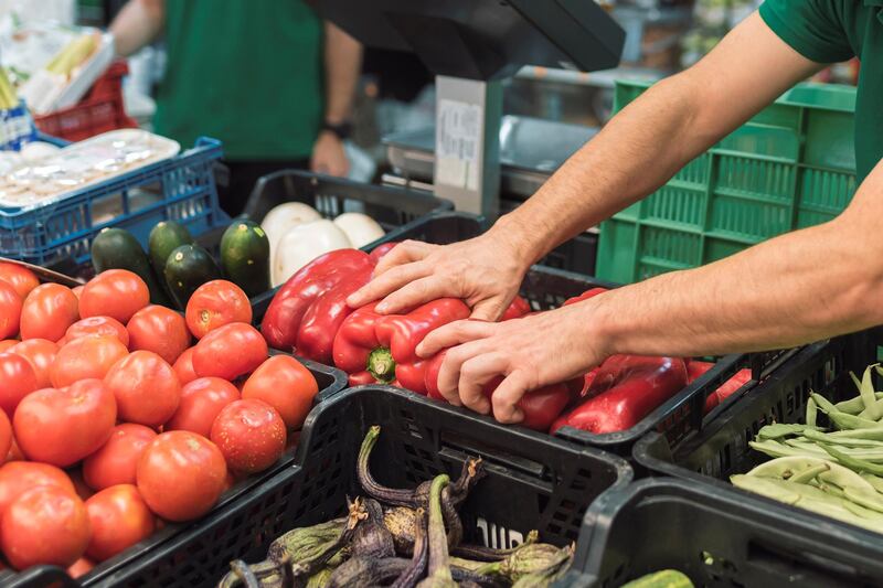 a shopkeeper placing fruit in the greengrocer's. Fruit concept