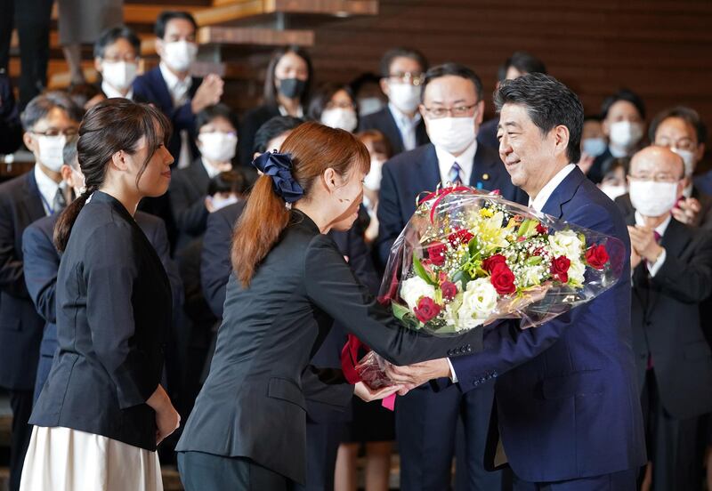 Japan's outgoing Prime Minister Shinzo Abe receives a bouquet upon his departure from the the prime minister official residence in Tokyo.  EPA