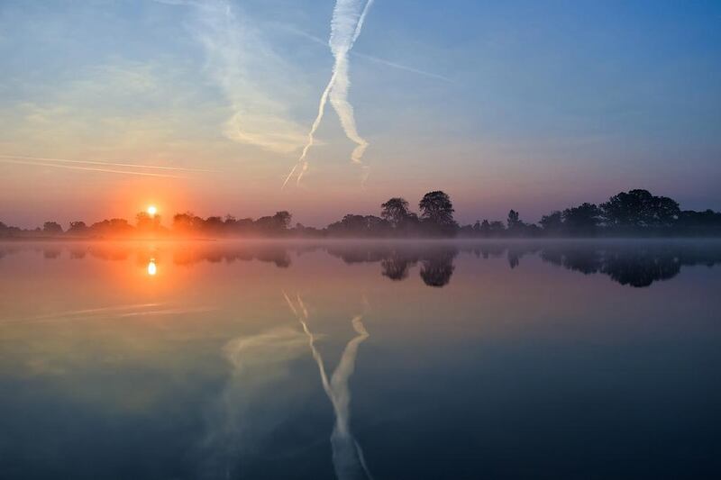 The rising sun’s light is creating a spectrum of colors in the morning sky as it is reflected in the calm waters of the Oder river near Reitwein, Germany, on the border to Poland. Patrick Pleul / EPA