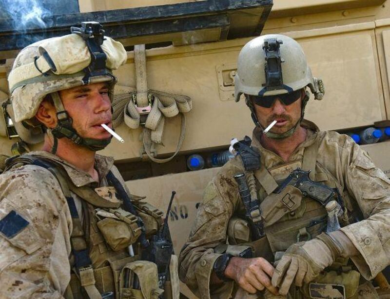 US Marine Staff Sergeant David S. Spicer (33) (R) of 1st Combat Engineering Battalion of 2nd Marine Expeditionary Brigade smokes before their team sets out to search for Improvised Explosive Devices (IED) in Garmsir district of Helmand Province on July 13, 2009. A foot patrol was advancing painstakingly with metal detectors and bare hands to defuse bombs planted on a rough track when an explosion shot a cloud of dust and rocks into the sky in southern Afghanistan's Helmand province at dusk, killing Sergeant Michael W. Heede Junior and Staff Sgt. David S. Spicer. The unit has been in Afghanistan only months, part of a surge of 21,000 extra US troops sent to quell a Taliban insurgency that is testing Western military endurance and shows signs of expanding beyond southern and eastern heartlands.