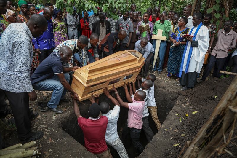 Relatives mourn as the coffin of Florence Masika, who was killed along with her son Zakayo Masereka by suspected rebels as they retreated from Saturday's attack on the Lhubiriha Secondary School, is buried in Nyabugando, Uganda. The attack by extremists left at least 42 people dead, most of them pupils. AP