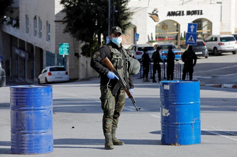 A member of Palestinian security forces wearing a mask stands guard outside Angel Hotel, where American tourists have been quarantined amid coronavirus precautions, in Beit Jala town in the Israeli-occupied West Bank. Reuters