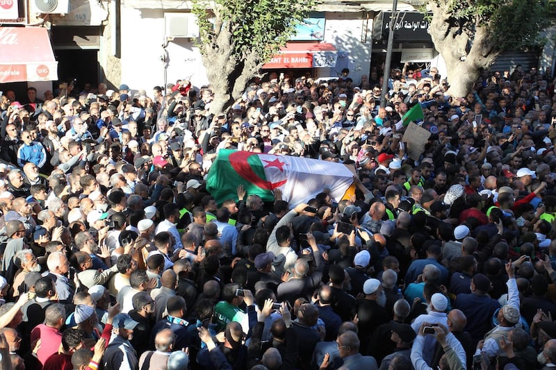 TOPSHOT - Mourners carry the coffin of Abassi Madani, founder of Algeria's banned Islamic Salvation Front (FIS), in the central Belcourt neighbourhood of the capital Algiers on April 27, 2019.  Madani, who died in Qatar where he lived in exile, had called for armed struggle in 1992 after Algeria's military scrapped the country's first multi-party parliamentary election which the FIS had won, and pushed for the creation of an Islamic state in the North African nation. / AFP / -
