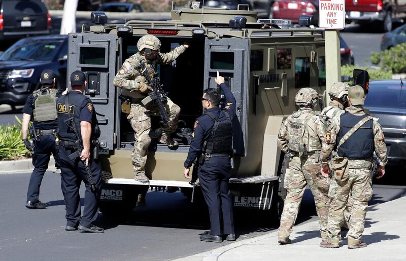 Heavily armed law enforcement personnel exit an armored vehicle outside the San Bruno building. AP Photo/Marcio Jose Sanchez