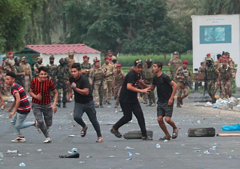 Iraqi security forces chase anti-government protesters in Baghdad, Iraq. AP Photo