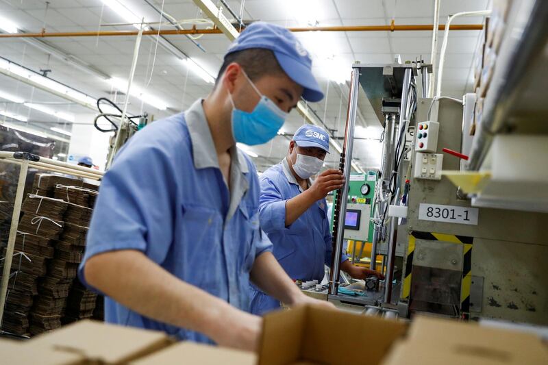 FILE PHOTO: Employees wearing masks work at a factory of the component maker SMC during a government organised tour of its facility following the outbreak of the coronavirus disease (COVID-19), in Beijing, China May 13, 2020. REUTERS/Thomas Peter/File Photo