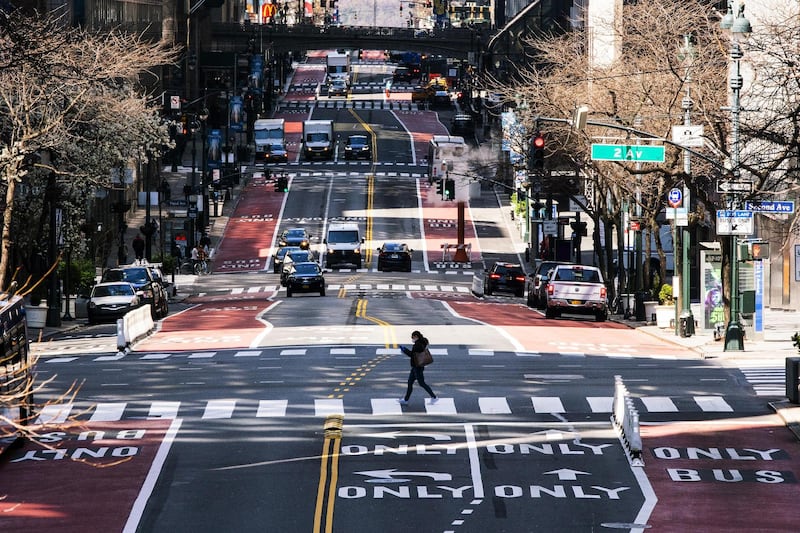 NEW YORK, NY - MARCH 26: A woman crosses 42nd Street as it is seen with low traffic due to the coronavirus outbreak on March 26, 2020 in New York City. Across the country schools, businesses and places of work have either been shut down or are restricting hours of operation as health officials try to slow the spread of COVID-19.   Eduardo Munoz Alvarez/Getty Images/AFP