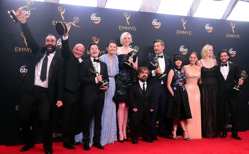 Cast & crew of Game of Thrones pose with the Emmy for Outstanding Drama Series. AFP

