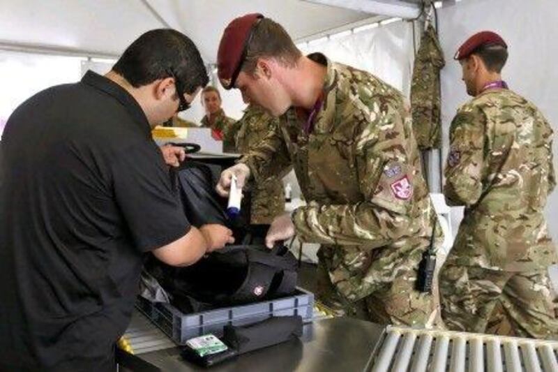 British soldiers check a bag at the entry of Olympic Park in Stratford, London in the lead-up to the Olympic Games from July 27.