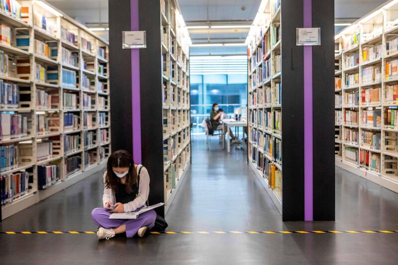 A visitor sits on the floor and reads in the library in Guangzhou, Guangdong province, China. EPA