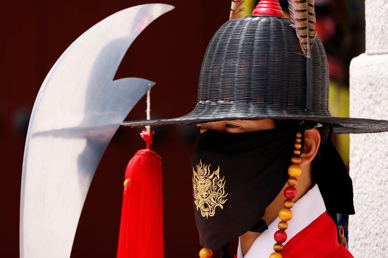 A man wearing traditional dress wears a mask to prevent the spread of the coronavirus during the daily re-enactment of the changing of the Royal Guards at Gyeongbok Palace in central Seoul. Reuters