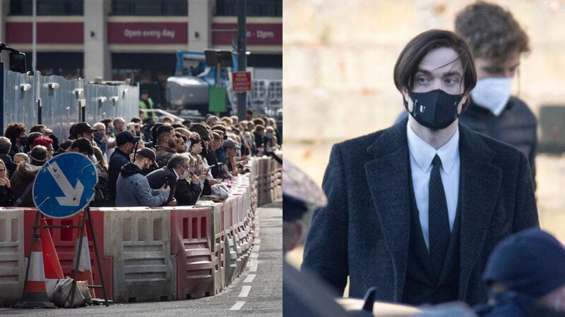 Left: Members of the public watching filming of The Batman movie outside St. George’s Hall, Liverpool. Right: Robert Pattinson on set. Getty Images