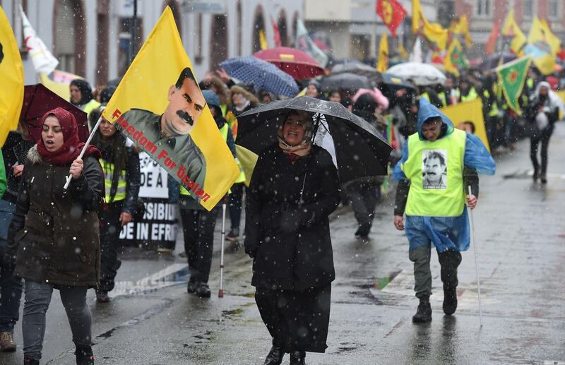 Participants wave flags and banners depicting jailed founding member and leader of the Kurdistan Worker's Party (PKK) Abdullah Ocalan during a demonstration asking for Ocalan's release in Strasbourg, eastern France, on February 17, 2018.
About 10,000 Kurds marched on February 17 in Strasbourg to demand as every year the release of their historic leader Abdullah Ocalan, imprisoned in Turkey, but also to protest against the Turkish offensive in the Kurdish enclave of Afrin in Syria. / AFP PHOTO / PATRICK HERTZOG