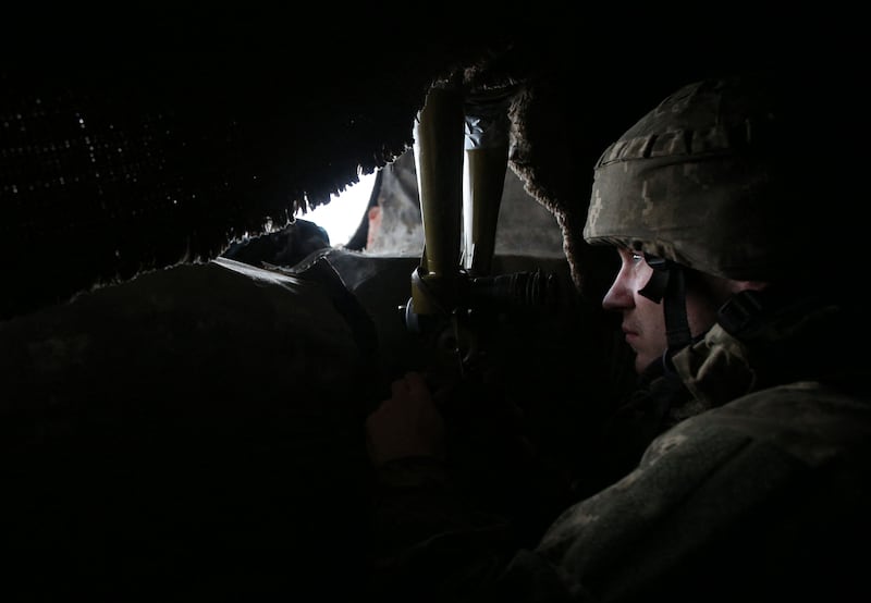 A Ukrainian Military Forces serviceman looks through a spyglass on the front line with Russia-backed separatists not far from Novolugansk in the Donetsk region. AFP