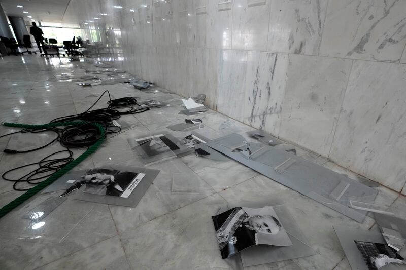 Photos of former Brazilian presidents lay scattered on the floor of the lobby of Planalto Palace. AP