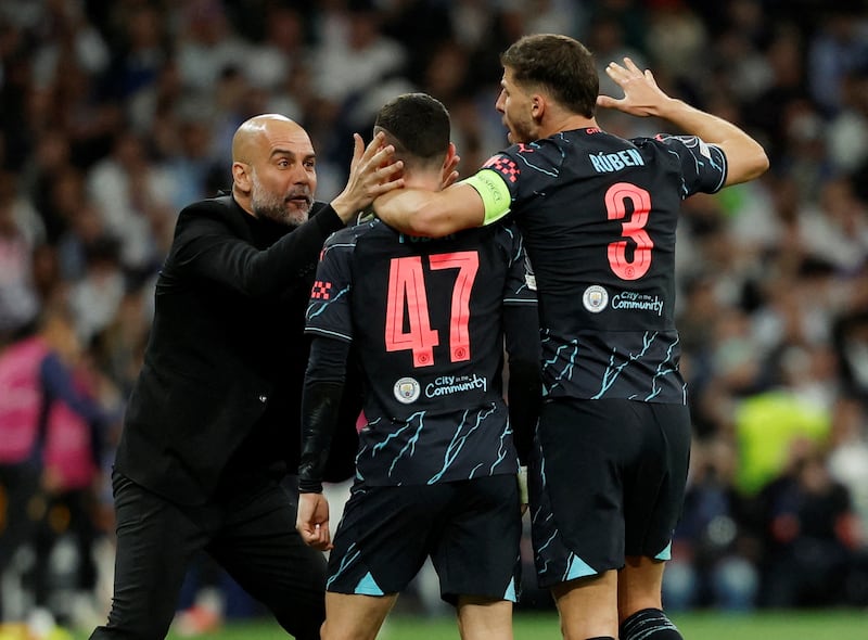 Phil Foden celebrates scoring Manchester City's second goal with manager Pep Guardiola and Ruben Dias. Reuters