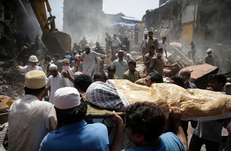 The body of a victim is carried out from the site of a building collapse in Mumbai. Rafiq Maqbool / AP Photo