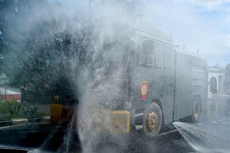 A water cannon vehicle sprays disinfectant amid a surge of coronavirus disease (COVID-19) cases in Tibawa, Gorontalo province, Indonesia.