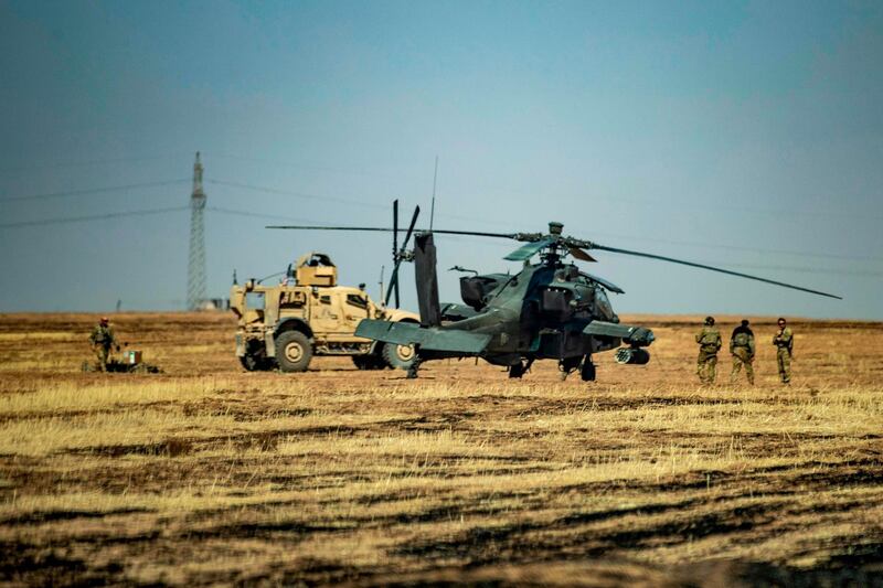 US soldiers and military vehicles stand next to an attack helicopter near the town of Tal Haddad in Syria's Hassakeh province. AFP