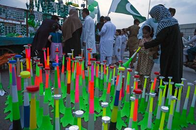 A girl purchases a horn from a roadside market on the eve of Pakistan's Independence Day celebrations in Peshawar. AFP